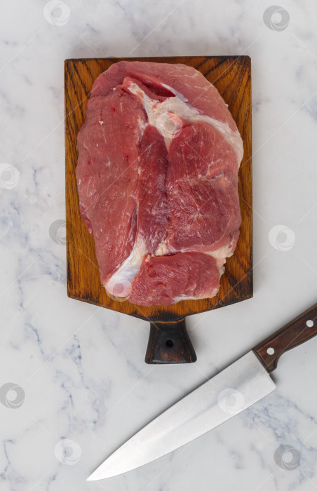 Скачать Органическое сырое свиное мясо на разделочной доске готово к приготовлению. Мрамор фотосток Ozero