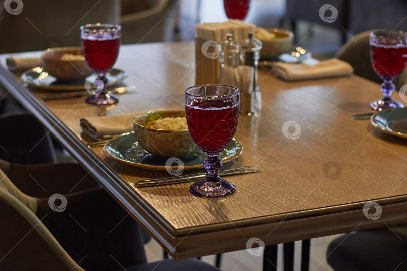 Скачать сервировка стола бокалы с компотом, тарелки с салатом фотосток Ozero