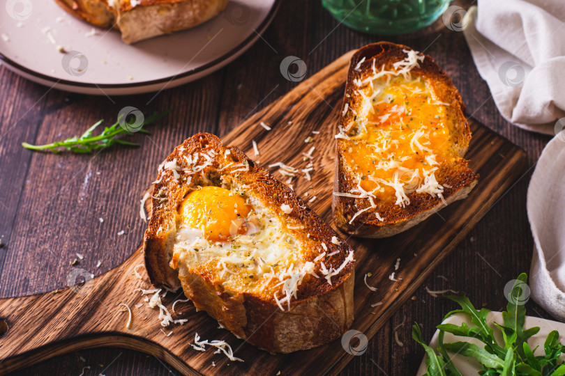 Скачать Аппетитная бриошь, запеченная с яйцом и сыром на доске фотосток Ozero