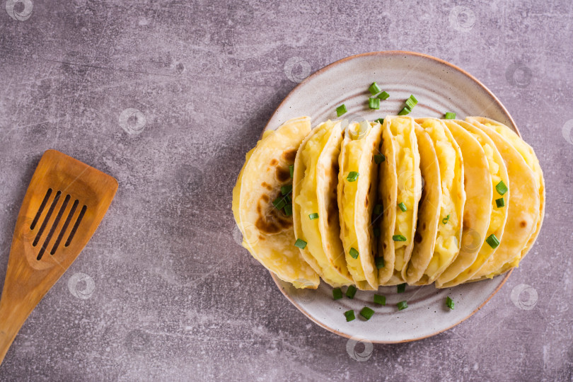 Скачать Тонкие лепешки с начинкой из картофельного пюре с луком ложатся как на фотосток Ozero