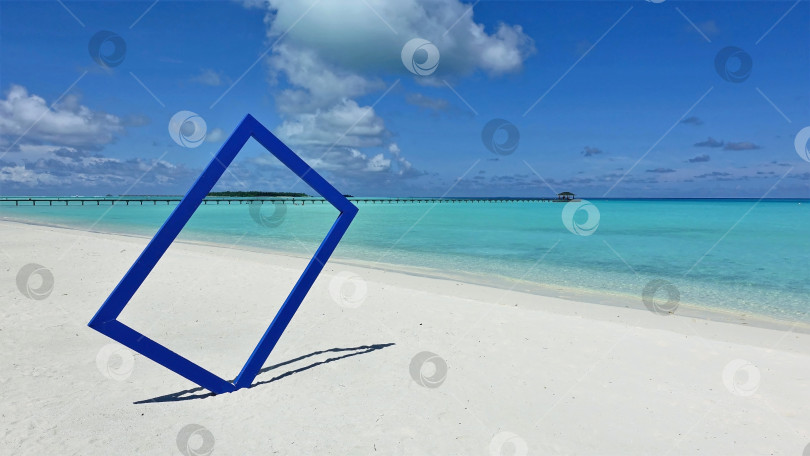 Скачать На белом песке пляжа стоит голубая рамка для фотографирования. фотосток Ozero