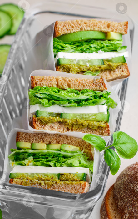 Скачать Бутерброд из ржаного хлеба с моцареллой, авокадо, огурцом, зеленым салом фотосток Ozero
