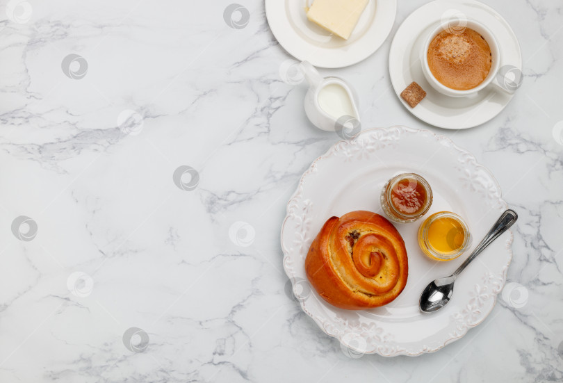 Скачать Сладкая булочка с изюмом, джемом и медом в белой тарелке на ма фотосток Ozero