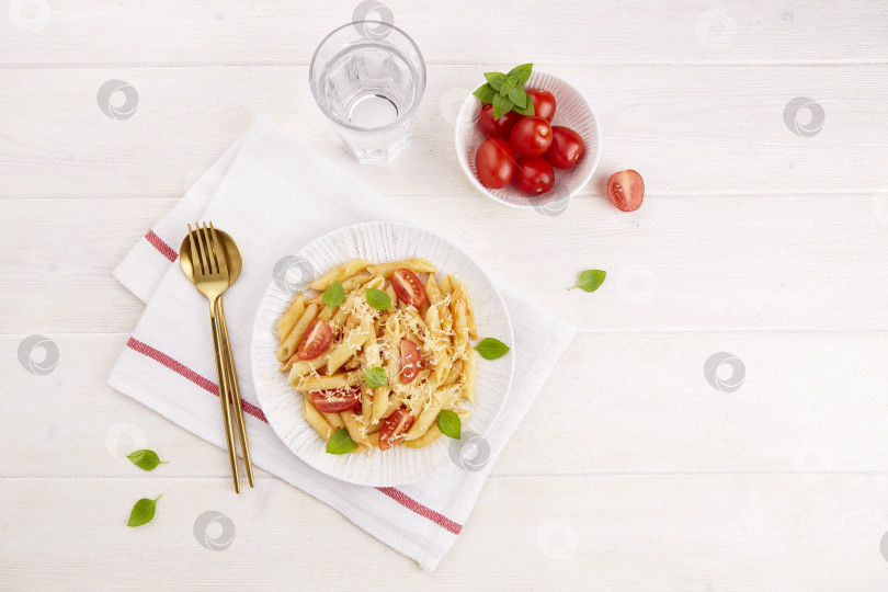 Скачать Итальянская паста пенне с помидорами, томатным соусом, базиликом на светлом фоне. фотосток Ozero