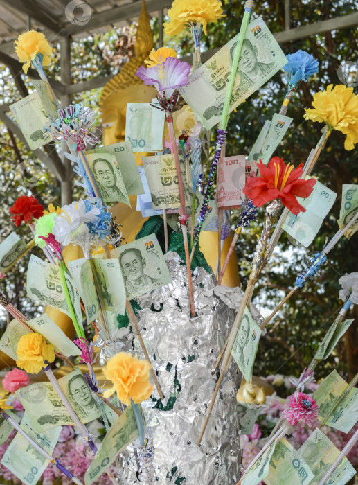 Скачать Тайский бат и искусственные цветы на буддийском денежном дереве в качестве подарков. фотосток Ozero