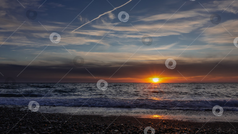 Скачать Вечерние сумерки. Заходящее солнце сияет над морем. фотосток Ozero