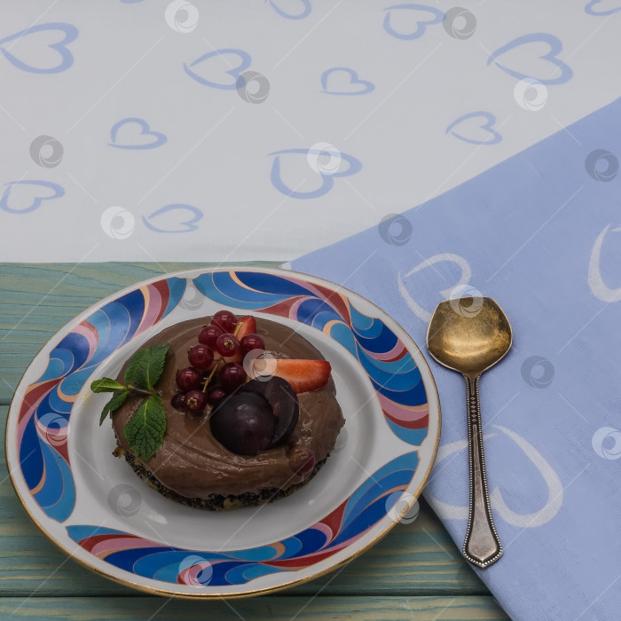 Скачать На синем деревянном подносе стоит тарелочка с бисквитным тортом с шоколадным кремом. фотосток Ozero