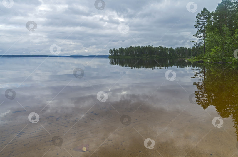 Скачать Облака и прибрежный лес отражаются в прозрачном озере фотосток Ozero