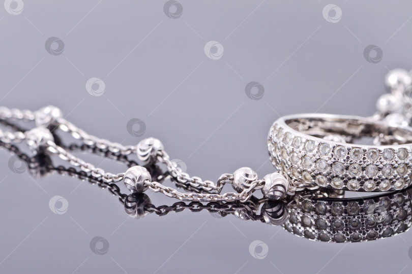 Скачать Серебряное кольцо с драгоценными камнями и тонкой серебряной цепочкой фотосток Ozero