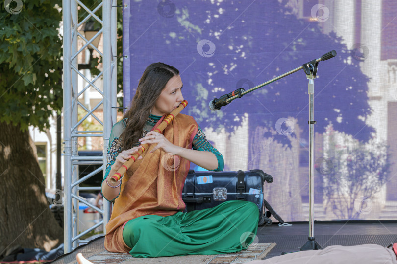 Скачать Молодая женщина исполняет индийскую мелодию на празднике йоги в парке Царицыно. фотосток Ozero