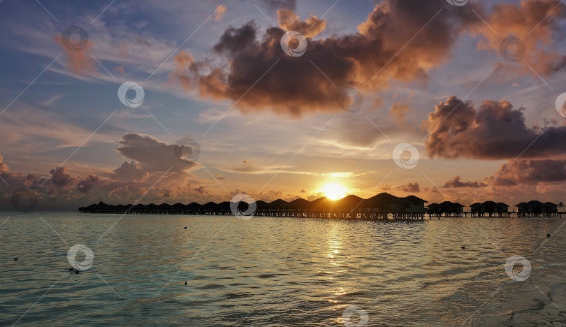 Скачать Фантастический закат на Мальдивах. В голубом небе плывут розовые облака. фотосток Ozero