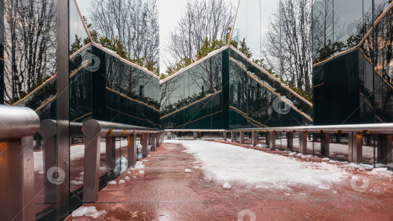 Скачать Красная дорожка в парке. По бокам расположен черный зеркальный лабиринт с отражениями. фотосток Ozero