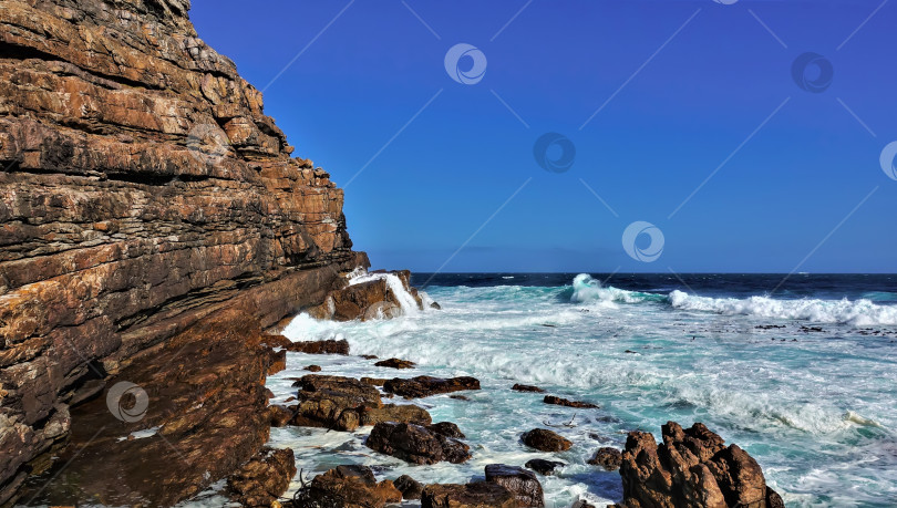 Скачать Бирюзовые волны бьются о скалы мыса Доброй Надежды. . Южная Африка фотосток Ozero