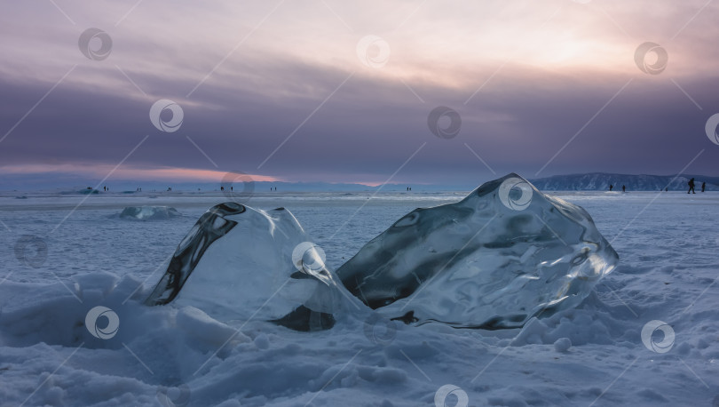 Скачать Большие прозрачные блестящие ледяные торосы на замерзшем и заснеженном озере. фотосток Ozero