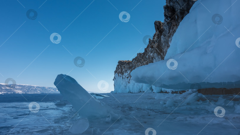 Скачать На поверхности покрытого льдом озера видны причудливые торосы. Зимний солнечный день. Озеро Байкал фотосток Ozero