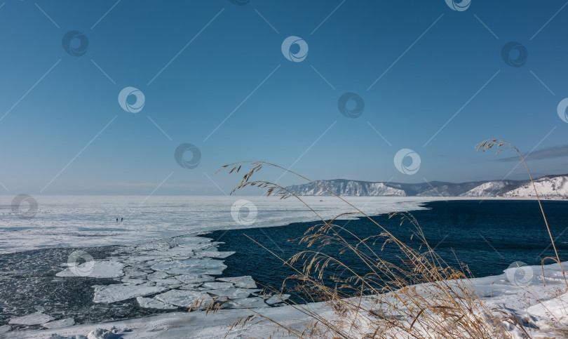 Скачать Озеро покрыто льдом. На границе с истоком незамерзающей реки находится льдина. фотосток Ozero