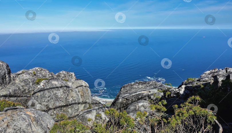 Скачать Живописные серые пятнистые валуны на фоне голубого Атлантического океана. фотосток Ozero