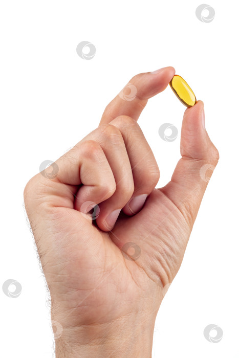 Скачать Мужская рука, держащая таблетку рыбьего жира, выделена на белом фоне. фотосток Ozero