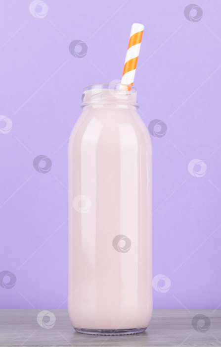 Скачать Бутылка вкусного молока на деревянном столе на фиолетовом фоне, крупным планом фотосток Ozero