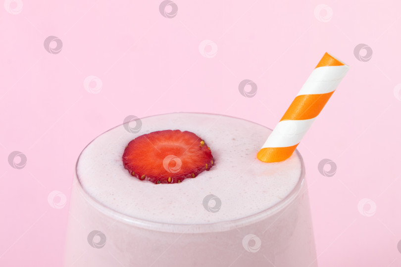 Скачать Клубничный молочный коктейль на розовом фоне с полосатой соломинкой фотосток Ozero