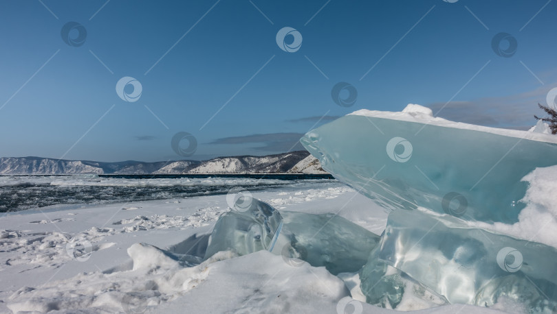 Скачать Бирюзовые ледяные торосы на заснеженном берегу. фотосток Ozero