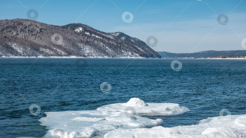 Скачать Незамерзающая река зимой. На берегу есть снег и лед. фотосток Ozero