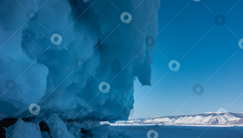 Скачать Основание скалы покрыто толстым слоем ледяных брызг и причудливых сосулек. фотосток Ozero