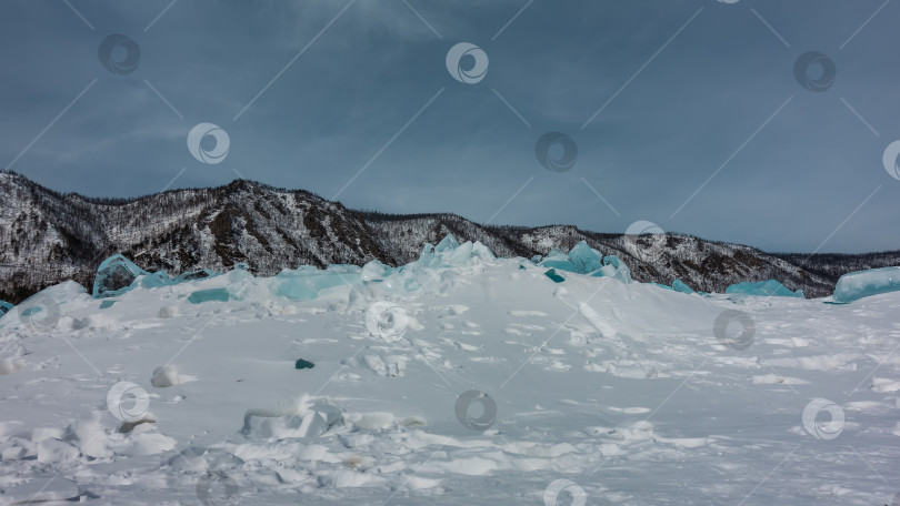 Скачать Прозрачные бирюзовые ледяные торосы возвышаются над замерзшим озером. Байкал фотосток Ozero