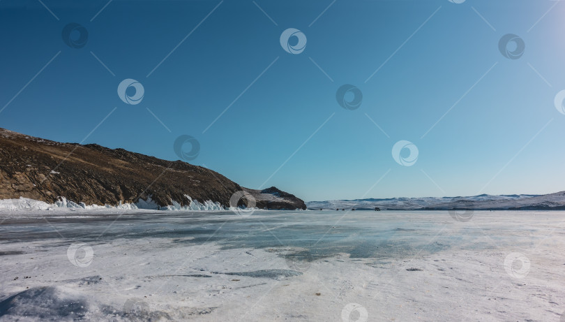 Скачать Снег лежит на поверхности замерзшего озера. Байкал зимой. фотосток Ozero