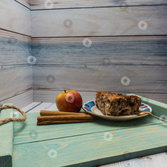 Скачать Бисквитный яблочный пирог с орехами. На тарелке лежит треугольный кусочек. фотосток Ozero