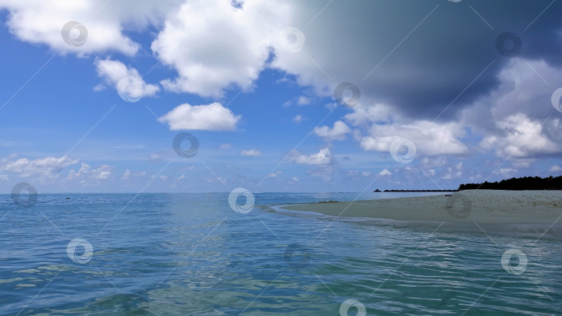 Скачать Аквамариновый океан спокоен. На горизонте виден ряд вилл на воде. фотосток Ozero