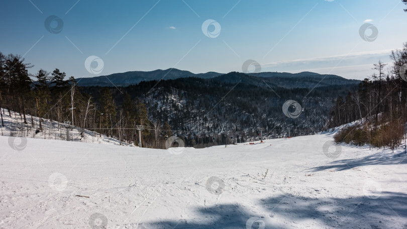 Скачать По заснеженному горному склону проходит кресельный подъемник. Лыжные трассы на снегу. фотосток Ozero