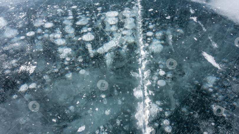 Скачать На бирюзовой поверхности льда видны трещины, следы от коньков. фотосток Ozero