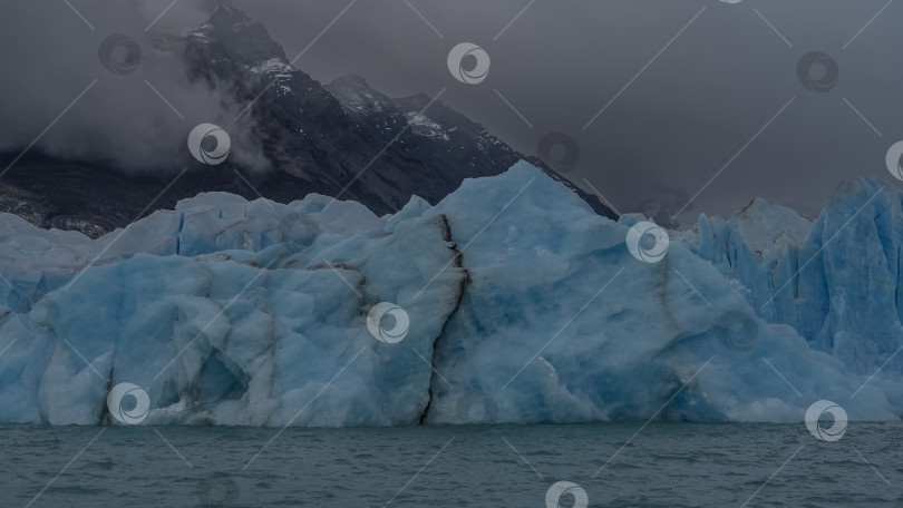 Скачать Впечатляющая стена из потрескавшегося голубого льда возвышается над бирюзовым ледниковым озером.  Аргентина. Эль-Калафате фотосток Ozero