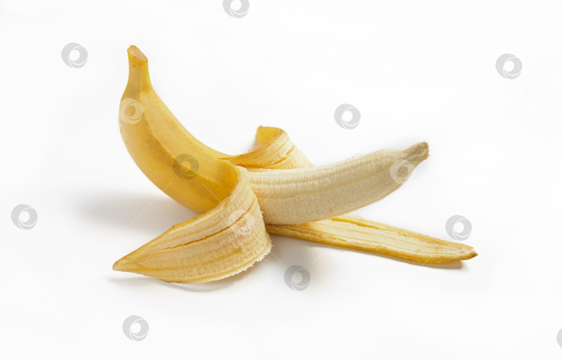 Скачать Наполовину очищенный спелый банан с кожурой на белом изолированном фоне фотосток Ozero