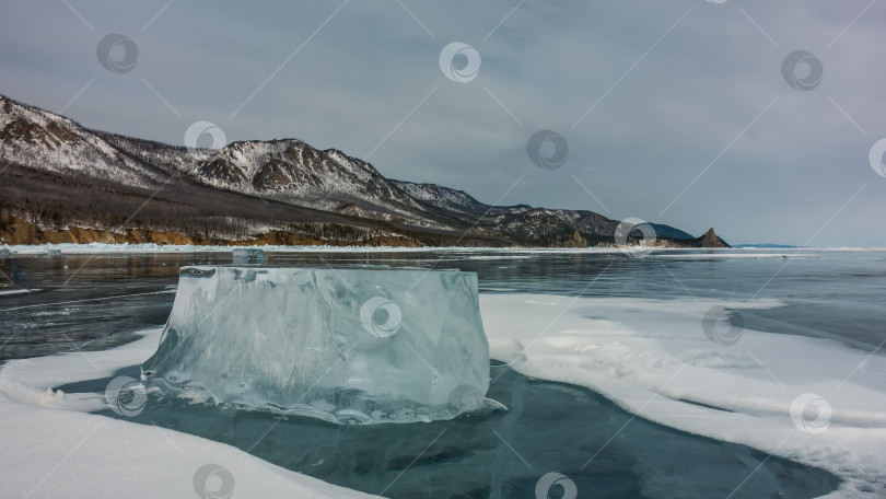 Скачать Большая сверкающая льдина лежит на замерзшем озере. Крупный план.  Байкал фотосток Ozero