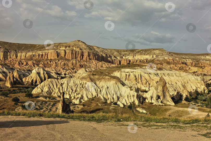 Скачать Уникальный ландшафт Каппадокии. Горы с розоватыми и желтыми складчатыми склонами фотосток Ozero