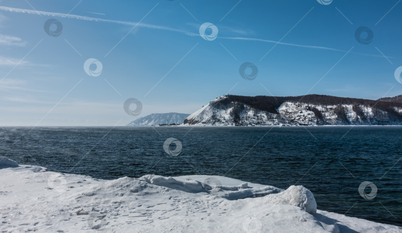 Скачать Незамерзающая река Ангара зимой. Берега покрыты снегом. фотосток Ozero