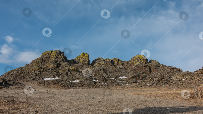 Скачать Причудливый горный хребет, лишенный растительности, на фоне голубого неба. фотосток Ozero