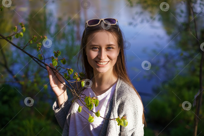 Скачать девушка в солнцезащитных очках у озера, держащая в руках ветку дерева фотосток Ozero