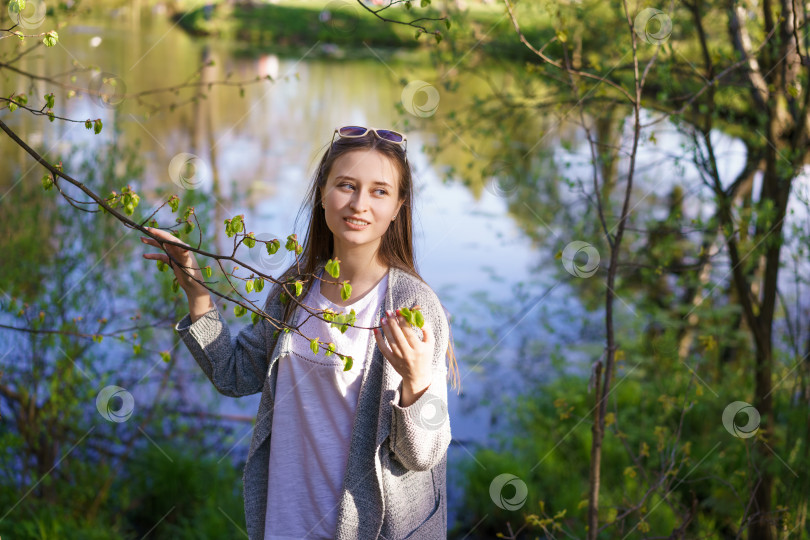 Скачать девушка в солнцезащитных очках у озера, держащая в руках ветку дерева фотосток Ozero