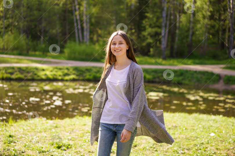 Скачать молодая девушка прогуливается у озера солнечным летним днем фотосток Ozero
