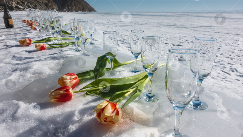 Скачать Подготовка к празднику. Пустые бокалы для вина стоят в ряд на снегу. фотосток Ozero