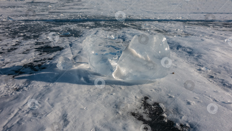 Скачать Прозрачные осколки льда на замерзшем озере. Солнечные блики по краям фотосток Ozero