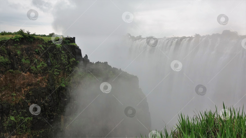 Скачать Мощные потоки водопада Виктория низвергаются в бездну. фотосток Ozero