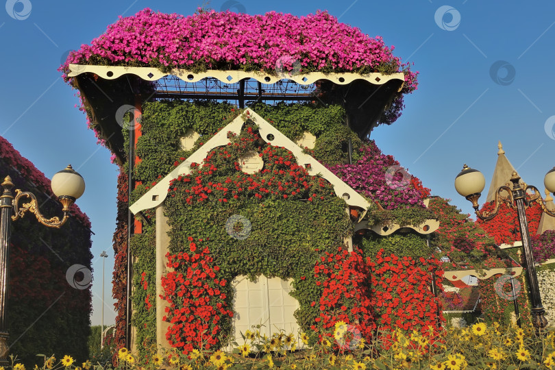 Скачать Декоративный сказочный домик в парке на фоне голубого неба. фотосток Ozero
