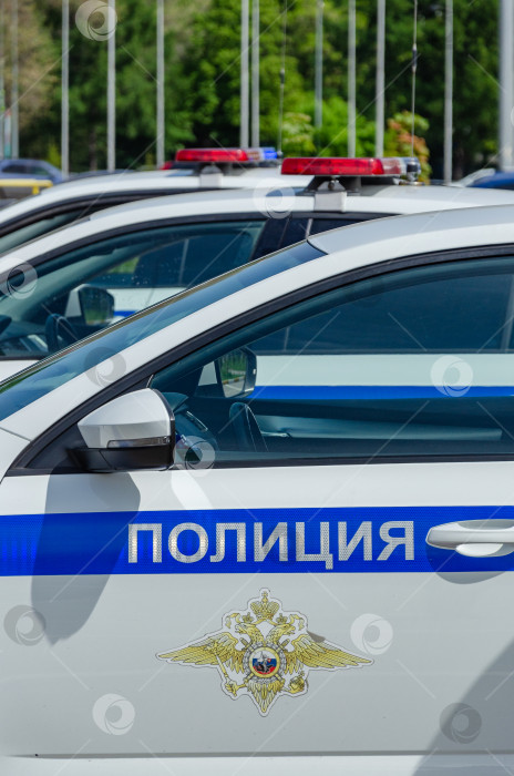 Скачать Ульяновск, Россия - 20 мая 2023 года: Дверь полицейской машины с логотипом и надписью POLICE и включенным проблесковым маячком на крыше. фотосток Ozero