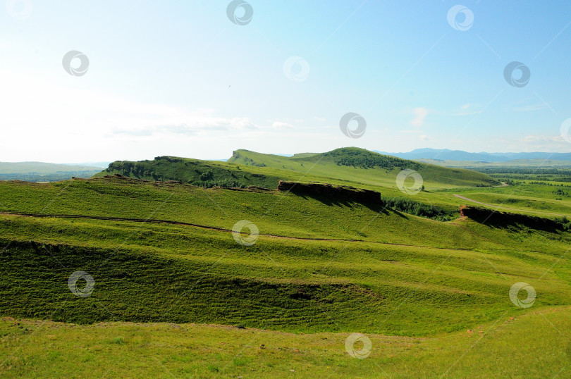 Скачать Высокие холмы и лощины в бескрайней степи под ясным летним небом в ясный солнечный день. фотосток Ozero