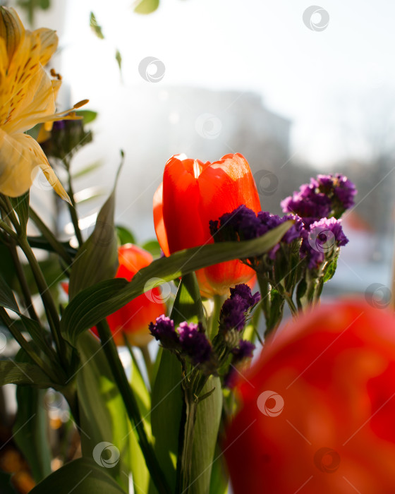 Скачать Букет цветов в помещении в солнечный день. Лилии, тюльпаны, полевые цветы сирени. Вертикальная фотография фотосток Ozero
