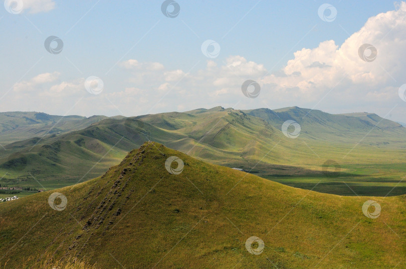Скачать Гребень высокого горного хребта проходит через степь в ясный солнечный день. фотосток Ozero
